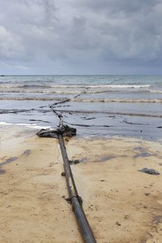 Pipeline on dirty beach as tool to suck crude oil on clean-up operation from crude oil spilled into Ao Prao Beach on July 31, 2013 in Rayong province, Thailand.