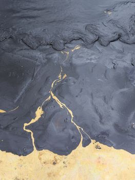 Texture of Crude oil spill on sand beach.