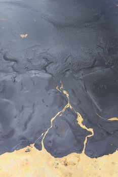 Texture of Crude oil spill on sand beach.