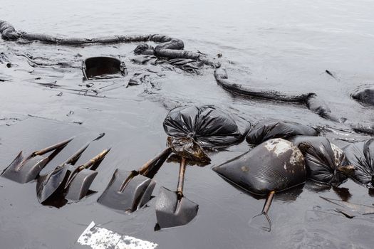 Spades, Absorbent paper, Oil Containment boom and Plastic Bags are some tools for the clean up operation on oil spill accident on Ao Prao Beach at Samet island on July 2013 in Rayong, Thailand.