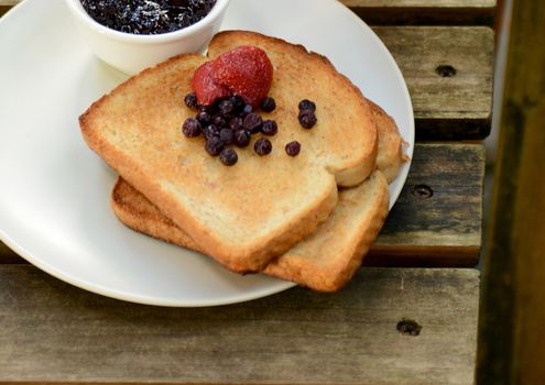 strawberry and blueberry toast with wooden background