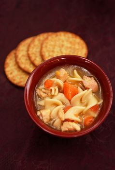 comfort food and chicken noodle soup in red bowl