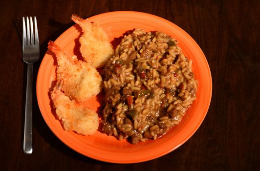 fried shrimp with jambalaya on orange plate for hearty meal