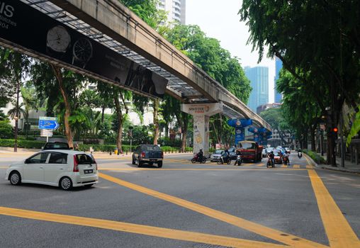 KUALA LUMPUR - JUN 15: City street with cars and  monorail way under road on Jun 15, 2013 in Kuala Lumpur, Malaysia. Kuala Lumpur is served by three separate rail systems with underground, elevated or at-grade lines.