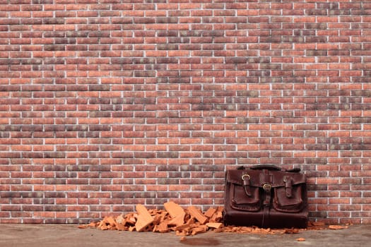 abandoned bag on a brick wall