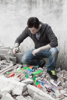 Teen painting with a sprays cans in the street