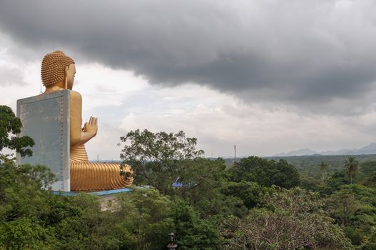 Heavy clouds over Buddha statue in Golden Temple in Dambulla, Sri Lanka