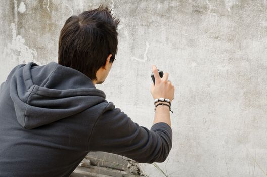 Graffiti artist about to start spraying a wall, copy space available