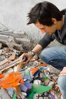 Teen painting in the street with sprays