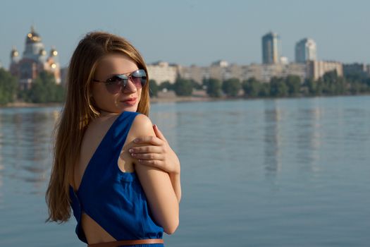 girl in a blue dress on the background of the river. Ukraine. Kiev. Obolon