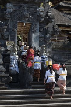 BALI, INDONESIA - SEP 26: Women with offers come in the temple gate for sacred ceremony in Goa Lawah Bat Cave on Sep 26, 2012 in Bali, Indonesia