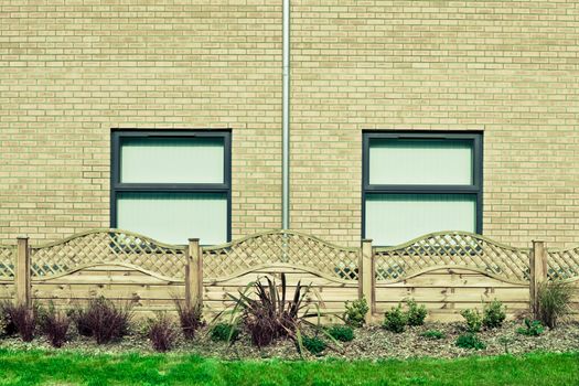 A modern building and neat garden with fence