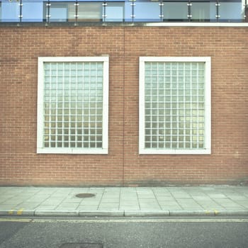 Two glass brick windows in a wall of an urban building