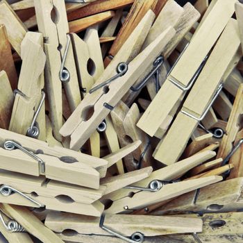 Many wooden clothes pegs as a background