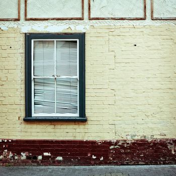 Window frame in a weathered wall of a house