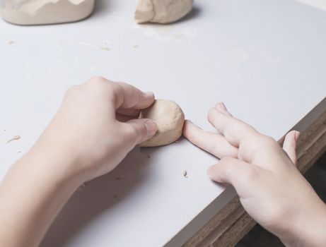 Girl make toyfrom clay. High resolution image.