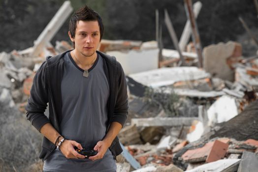 Guy playing with his console surrounded by rubble, a concept