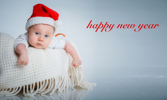 Christmas theme. A baby boy in a Santa suit in studio