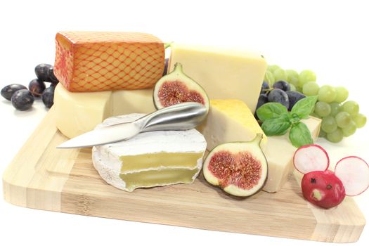 great selection of cheese with knife, grapes and figs