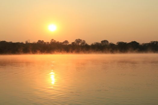 Sunrise at Kavango river whit mist on the water surface, Caprivi region. Namibia