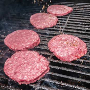 Photograph of   tasty beef burgers on the grill