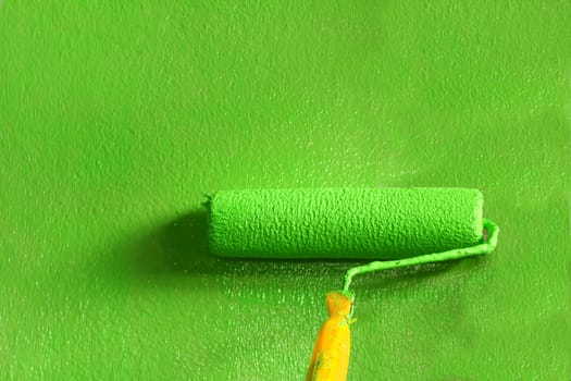 Wall painter using a paint roller painting a wall in motion