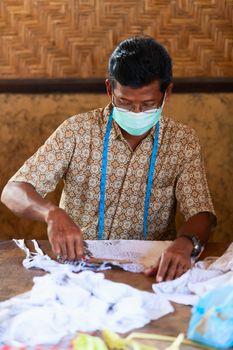 BALI, INDONESIA - Sep 21: Balinese man prepare stecil for batik, on Sep 21, 2012 in Bali, Indonesia. Batik-making is an important part of Indonesian culture. 