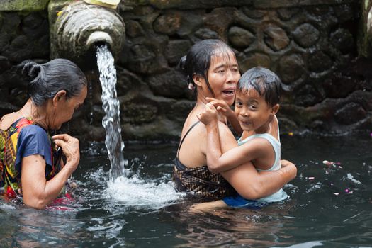 TIRTA EMPUL, INDONESIA - SEP 21: Bali prayers take a bath  in the sacred holy spring water on Sep 21, 2012 in Tirta Empul, Bali, Indonesia. It is famous place for purification of Bali people