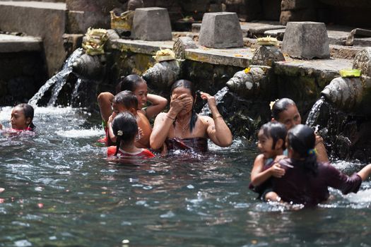 TIRTA EMPUL, INDONESIA - SEP 21: Bali prayers take a bath  in the sacred holy spring water on Sep 21, 2012 in Tirta Empul, Bali, Indonesia. It is famous place for purification of Bali people