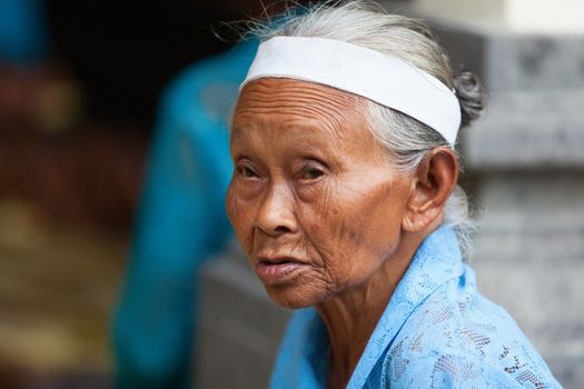 TAMPAK SIRING, BALI, INDONESIA - SEP 21: Old woman takes a part in Balinese community life for traditional offerings to gods preparing in temple Puru Tirtha Empul on Sep 21, 2012 in Tampak Siring, Bali, Indonesia