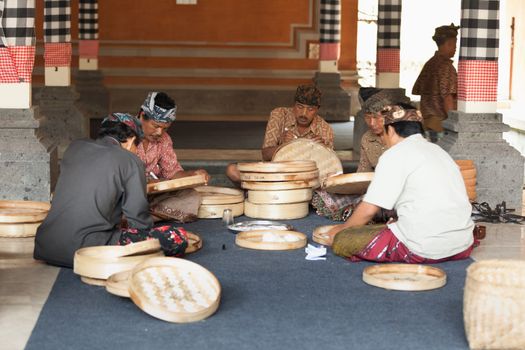 TAMPAK SIRING, BALI, INDONESIA - SEP 21: Men prepare baskets for balinese traditional offerings to gods in temple Puru Tirtha Empul on Sep 21, 2012 in Tampak Siring, Bali, Indonesia