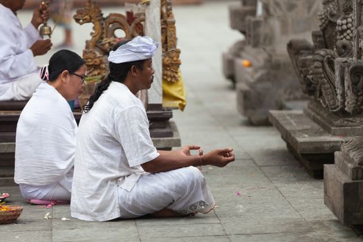 TAMPAK SIRING, BALI, INDONESIA - SEP 21: People praying at holy spring water temple Puru Tirtha Empul during the religious ceremony on Sep 21, 2012 in Tampak Siring, Bali, Indonesia