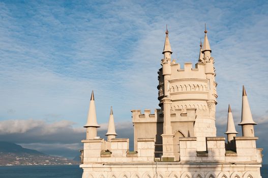 Swallow's Nest Castle tower, Crimea, Ukraine, with blue sky and Yalta town on background