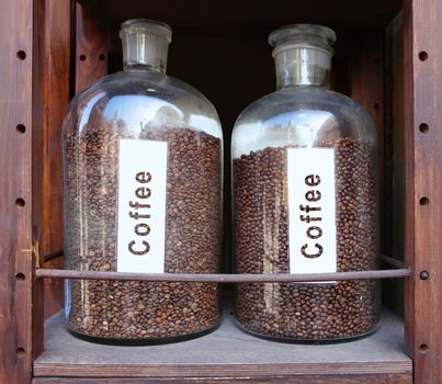 coffee grains in glass vessels on the wooden shelf