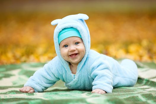 Portrait of happy baby boy in autumn park