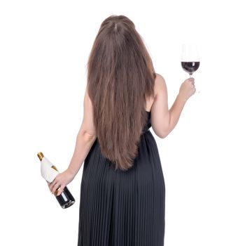 Woman with a bottle of red wine and a wineglass standing with her back, on white