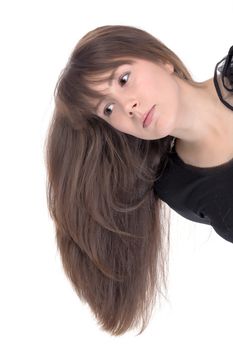 Attractive young woman with long brunette hair leaning sideways into the frame so that her hair falls straight down alongside her shoulder, isolated on white