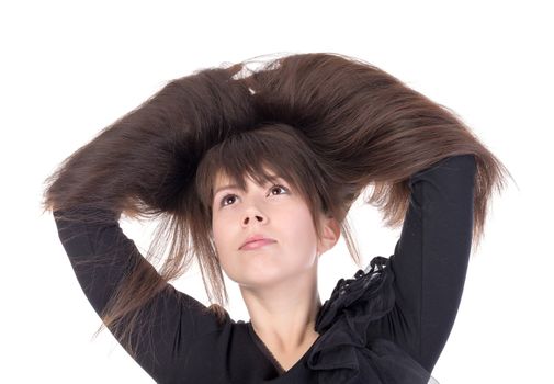 Attractive young woman with lovely long straight brunette hair running her hands through the tresses lifting them up above her head isolated on white