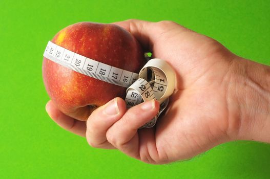 Diet Apple and Meter on the Hand on a Colored Background 