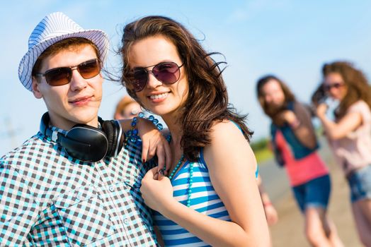 young couple standing on the road, having fun with friends