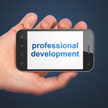Education concept: hand holding smartphone with word Professional Development on display. Mobile smart phone in hand on Blue background.
