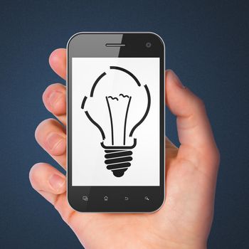 Finance concept: hand holding smartphone with Light Bulb on display. Generic mobile smart phone in hand on Dark Blue background.