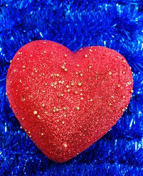 Christmas decoration red heart on background tinsel