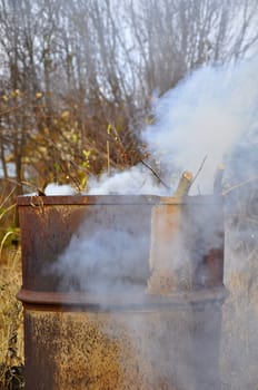 Smoke from a barrel with garbage on a country site