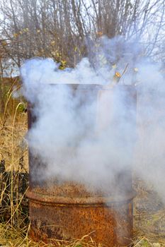 Smoke from a barrel with garbage on a country site