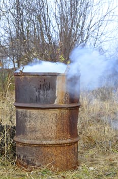 Smoke from a barrel with garbage on a country site