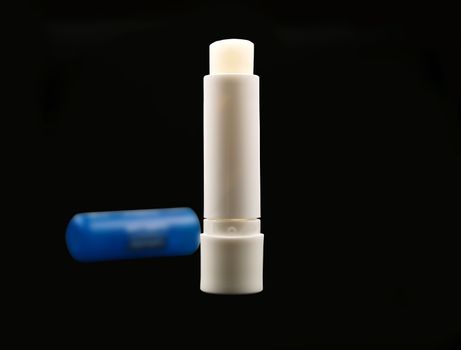 lip care stick with blue cover over black background