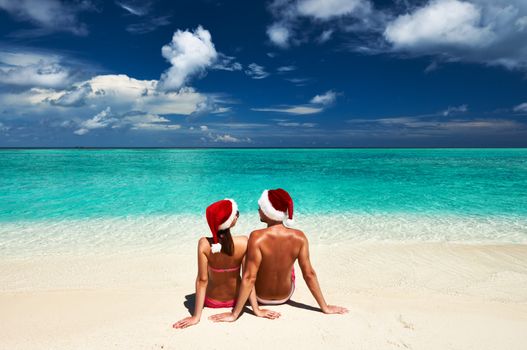 Couple in santa's hat on a tropical beach at Maldives