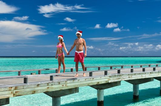 Couple on a tropical beach jetty at Maldives