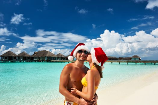 Couple in santa's hat on a tropical beach at Maldives